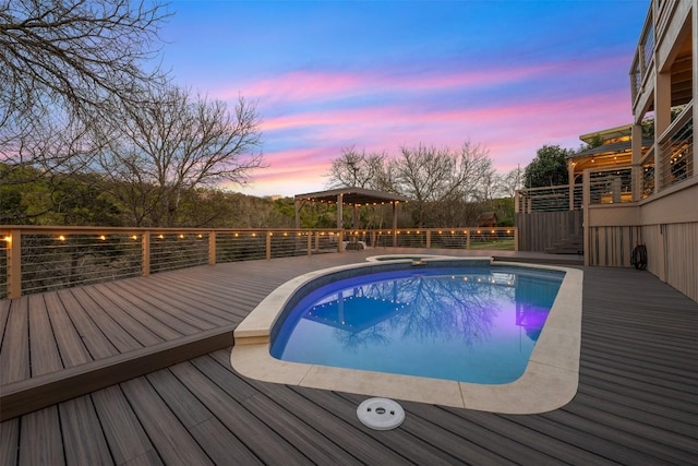 pool at dusk with a gazebo and a deck