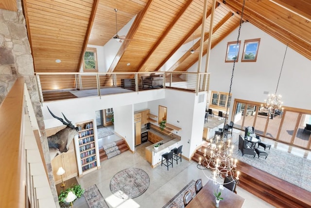 living room with beam ceiling, high vaulted ceiling, ceiling fan with notable chandelier, and wooden ceiling