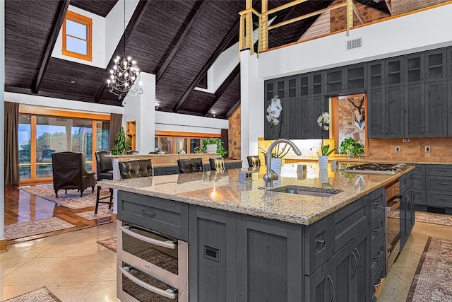 kitchen featuring sink, high vaulted ceiling, an island with sink, and wooden ceiling