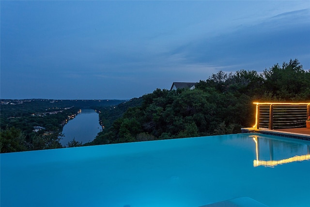 view of pool with central AC and a water view