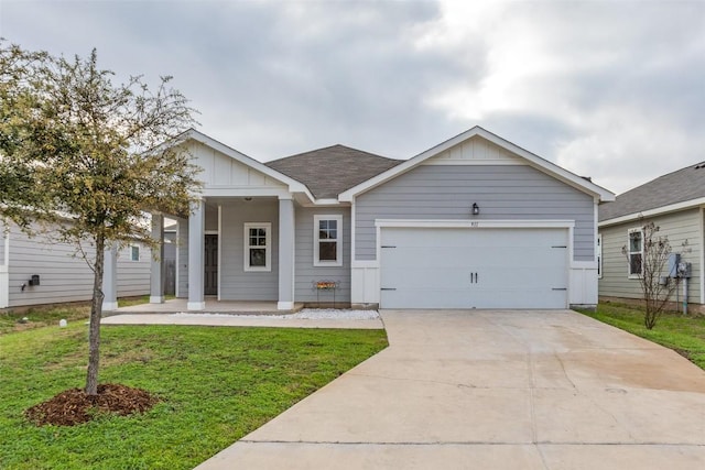 single story home with a garage, a front yard, and covered porch