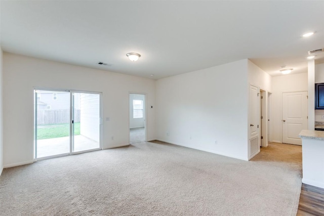 spare room featuring light carpet