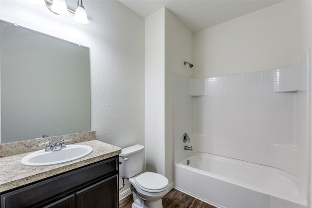 full bathroom featuring vanity, hardwood / wood-style floors, tub / shower combination, and toilet