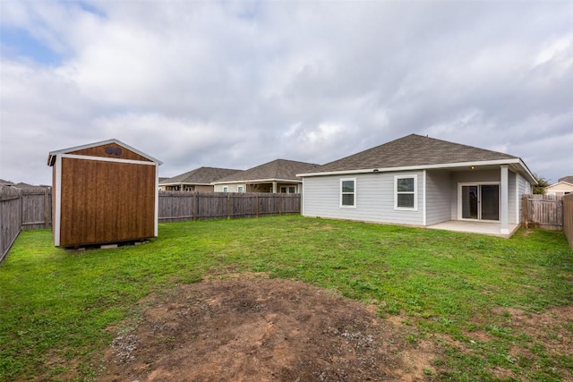 rear view of house with a shed, a yard, and a patio