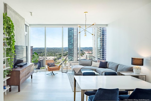 living room with an inviting chandelier, floor to ceiling windows, and light hardwood / wood-style flooring