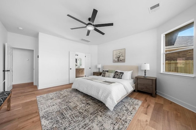 bedroom featuring ensuite bath, light hardwood / wood-style floors, and ceiling fan