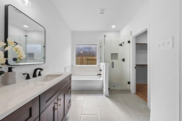 bathroom with vanity, plus walk in shower, and tile patterned flooring