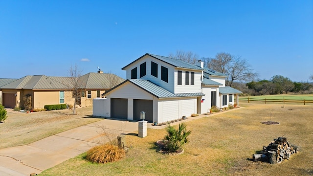 1210 Sun Ray, Horseshoe Bay, TX 78657 - view of front of house featuring a metal roof, concrete driveway, a chimney, a garage, and a standing seam roof