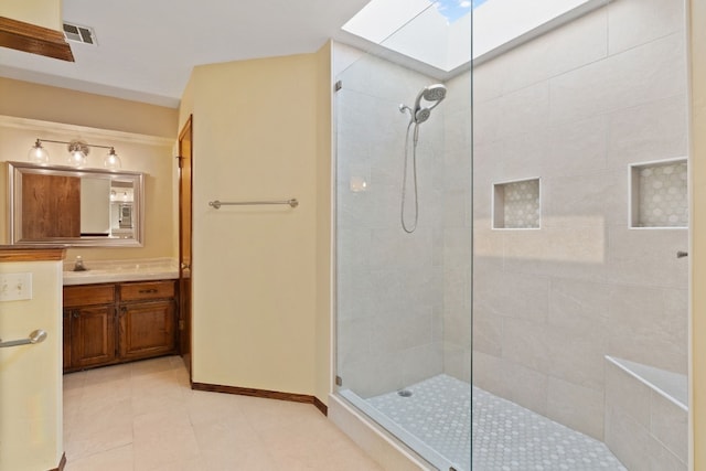 bathroom featuring vanity, tiled shower, tile patterned floors, and a skylight