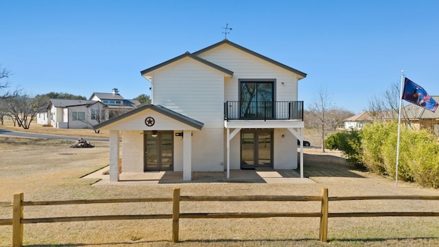 view of front of house featuring a balcony and a patio area