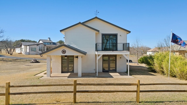 1210 Sun Ray, Horseshoe Bay, TX 78657 - view of front of home with french doors, a balcony, a fenced front yard, and brick siding