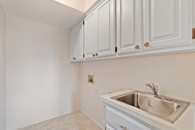 laundry room featuring sink, hookup for a washing machine, cabinets, and light tile patterned floors