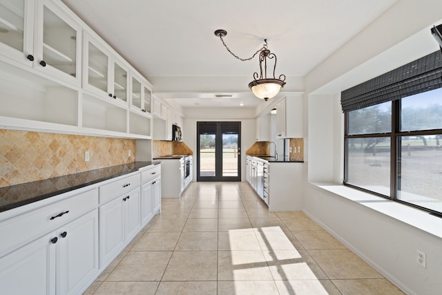 1210 Sun Ray, Horseshoe Bay, TX 78657 - kitchen with open shelves, dark countertops, backsplash, glass insert cabinets, and light tile patterned floors