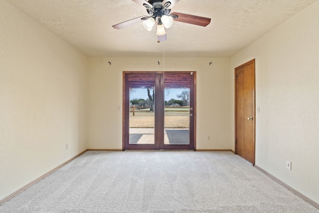 carpeted empty room featuring ceiling fan and a textured ceiling