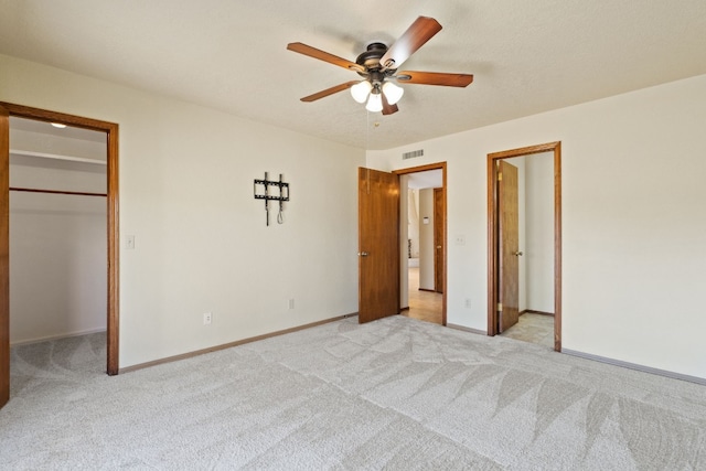 1210 Sun Ray, Horseshoe Bay, TX 78657 - unfurnished bedroom featuring a walk in closet, light colored carpet, and a ceiling fan