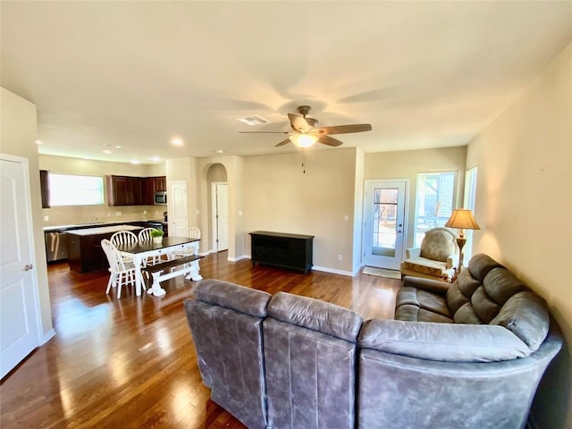 living room featuring dark wood-type flooring, a wealth of natural light, and ceiling fan