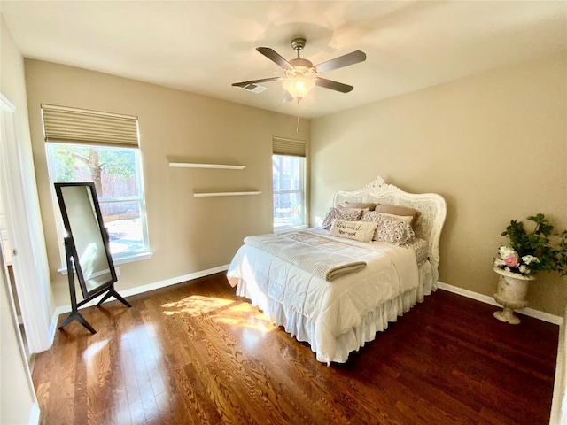 bedroom with dark wood-type flooring, ceiling fan, and multiple windows