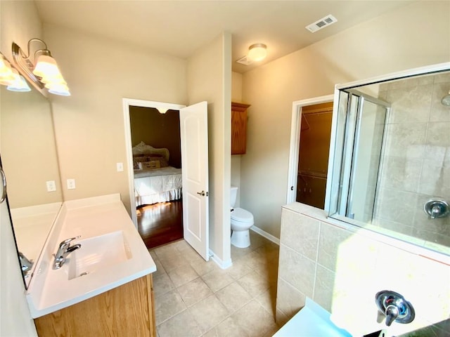 bathroom with tile patterned floors, vanity, toilet, and a shower with shower door