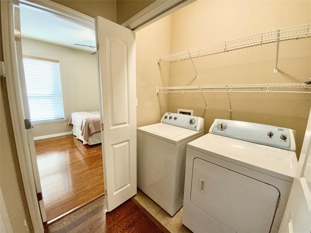 clothes washing area with dark hardwood / wood-style flooring and washing machine and dryer