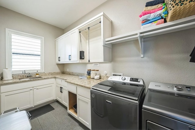 washroom with cabinets, sink, and independent washer and dryer