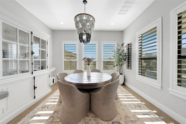 dining area with an inviting chandelier and light hardwood / wood-style floors