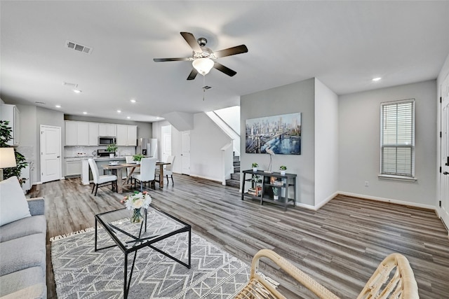 living room featuring hardwood / wood-style floors and ceiling fan