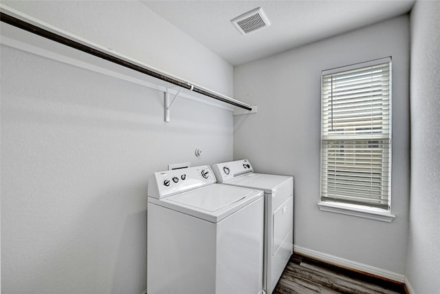 laundry area with washer and dryer and dark hardwood / wood-style flooring