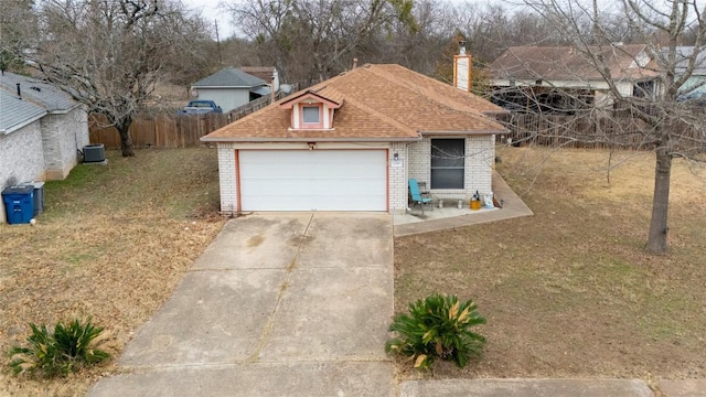 view of front facade featuring a garage and central air condition unit