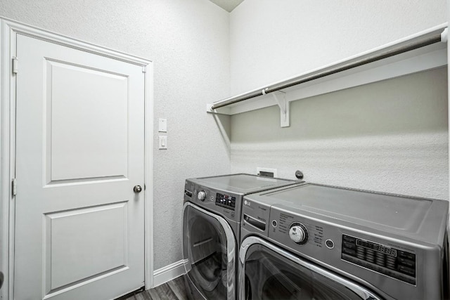 washroom featuring dark hardwood / wood-style flooring and washer and clothes dryer