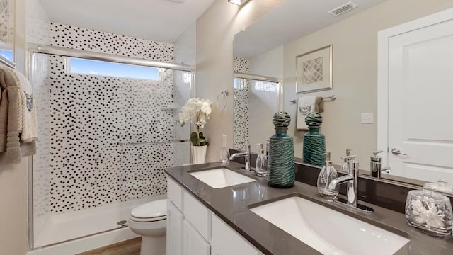 bathroom featuring vanity, toilet, and a shower with door