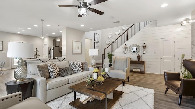 living room featuring ceiling fan and light hardwood / wood-style floors