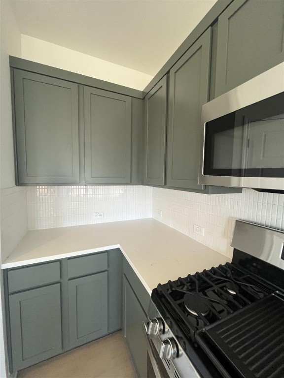 kitchen with backsplash and appliances with stainless steel finishes