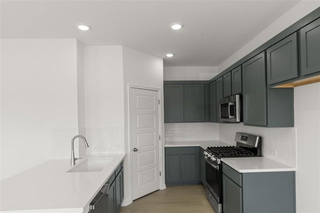 332 Witchhazel Way, San Marcos, TX 78666 - kitchen with appliances with stainless steel finishes, a sink, decorative backsplash, recessed lighting, and light countertops
