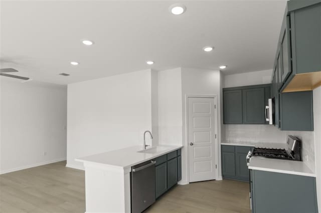 332 Witchhazel Way, San Marcos, TX 78666 - kitchen featuring appliances with stainless steel finishes, a sink, light wood-style floors, recessed lighting, and tasteful backsplash