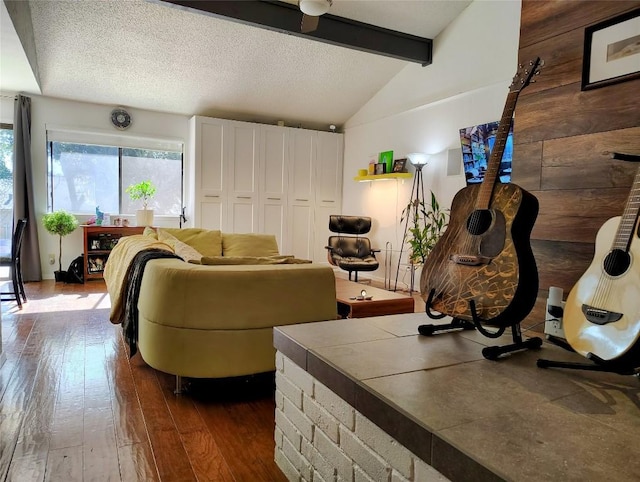 living room featuring vaulted ceiling with beams, dark wood-type flooring, and a textured ceiling