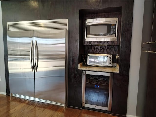 kitchen with built in appliances, beverage cooler, dark wood finished floors, and a toaster