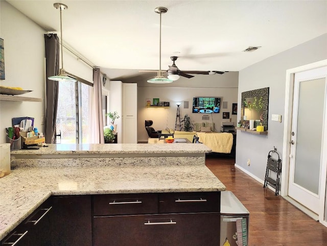 kitchen featuring dark brown cabinetry, visible vents, dark wood finished floors, open floor plan, and a peninsula