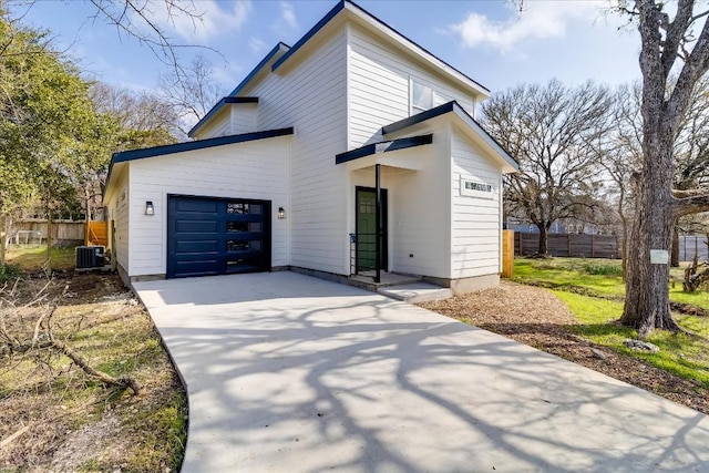 view of front of house featuring a garage and cooling unit