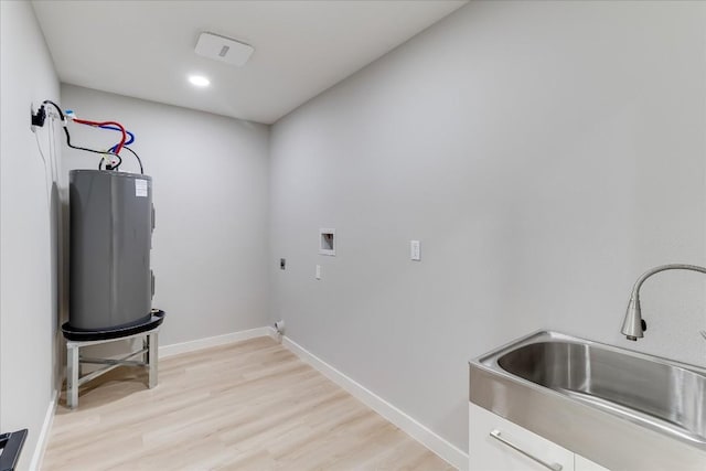 clothes washing area featuring sink, electric water heater, washer hookup, hookup for an electric dryer, and light hardwood / wood-style floors