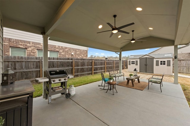 view of patio / terrace with an outbuilding, ceiling fan, a grill, a shed, and a fenced backyard