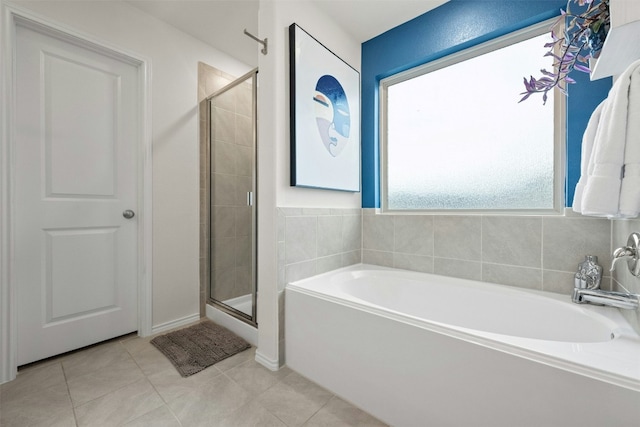 bathroom with tile patterned flooring, a bath, and a shower stall