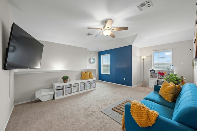 carpeted living room featuring baseboards, lofted ceiling, visible vents, and a ceiling fan