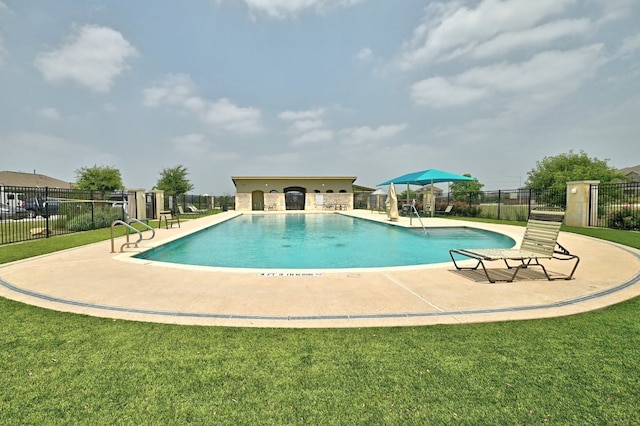 community pool featuring a patio, a lawn, and fence