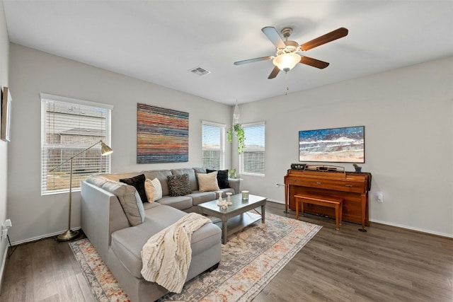 living room with a ceiling fan, baseboards, visible vents, and wood finished floors