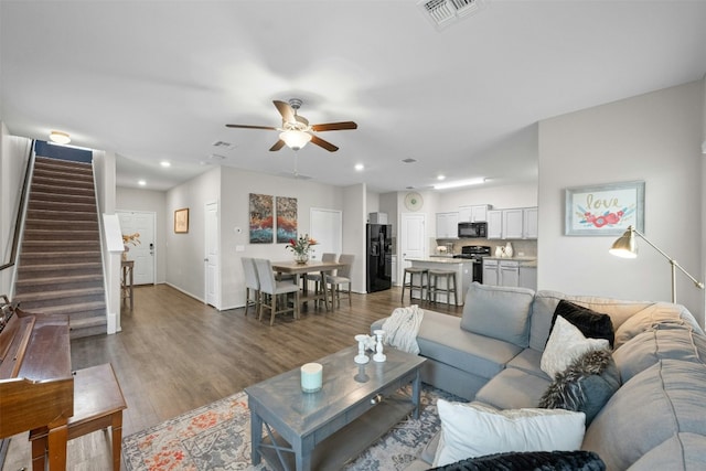 living room with visible vents, ceiling fan, stairway, wood finished floors, and recessed lighting