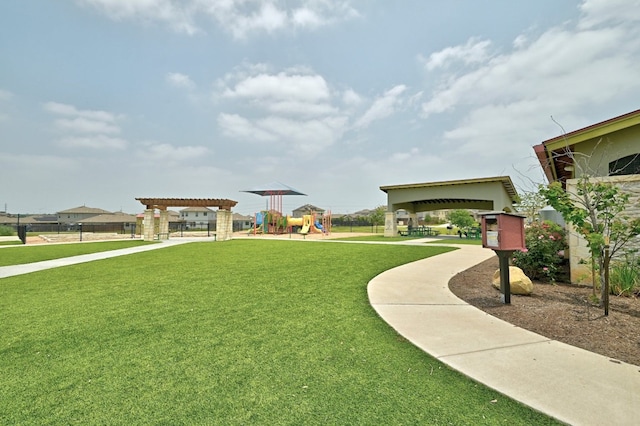 view of home's community with a pergola, playground community, and a yard