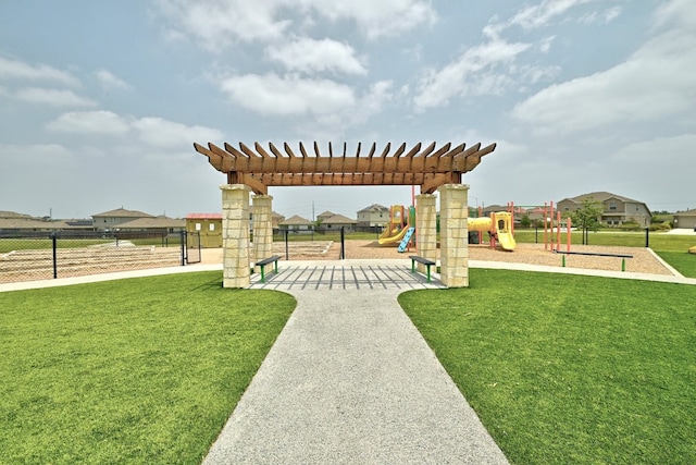 view of community featuring playground community, a yard, and fence