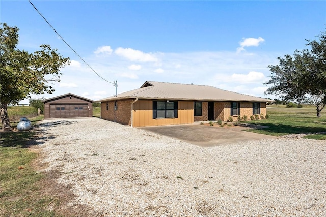 ranch-style home with an outbuilding, a garage, and a front lawn