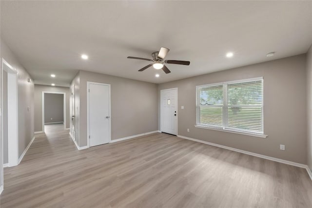 unfurnished room with ceiling fan and light wood-type flooring