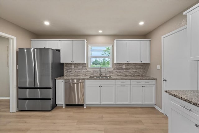 kitchen with white cabinetry, sink, light stone counters, and appliances with stainless steel finishes